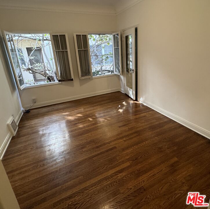 328 North Sycamore Avenue Los Angeles, CA 90036 - Photo 24 of 29 a view of an empty room with wooden floor and a window