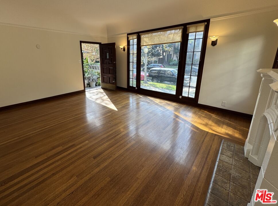 328 North Sycamore Avenue Los Angeles, CA 90036 - Photo 6 of 29 a view of an empty room with wooden floor and a window