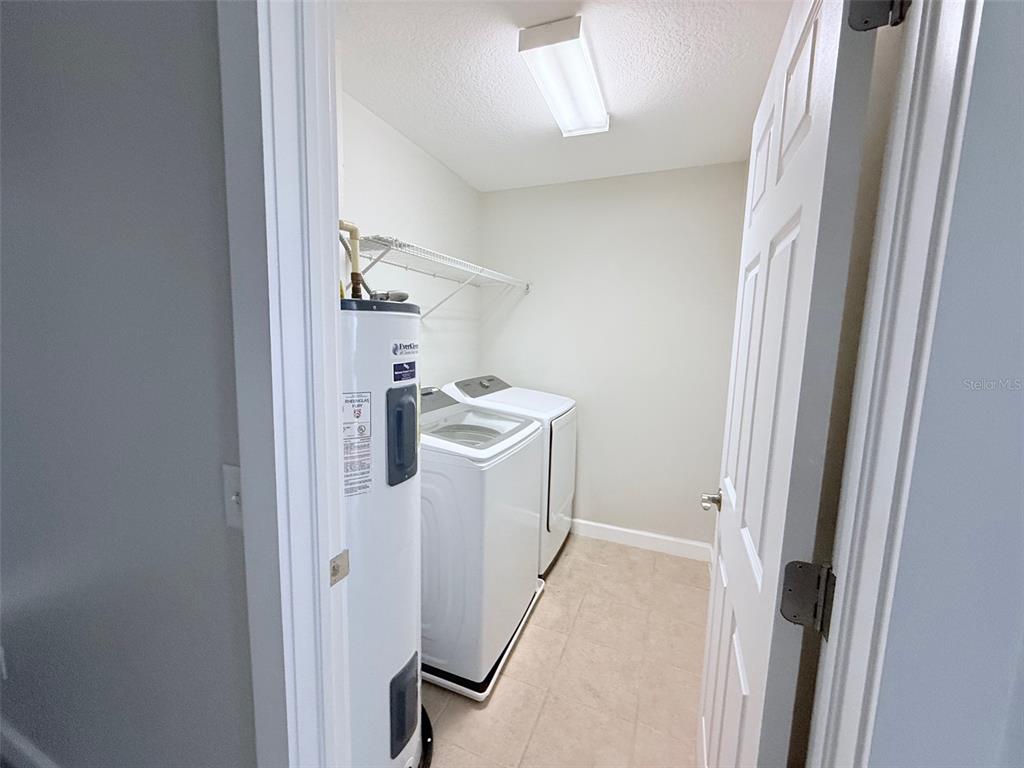 7350 Black Walnut Way Lakewood Ranch, FL 34202 - Photo 40 of 52 a view of a hallway with white cabinets and washer
