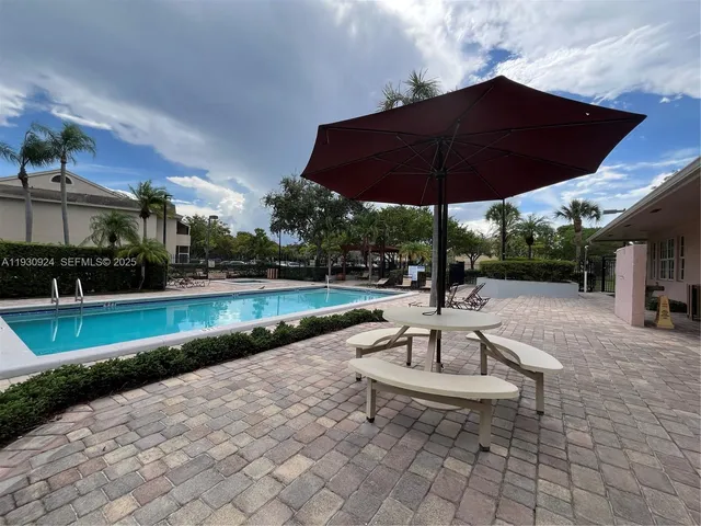 a view of a patio with a table and chairs under an umbrella