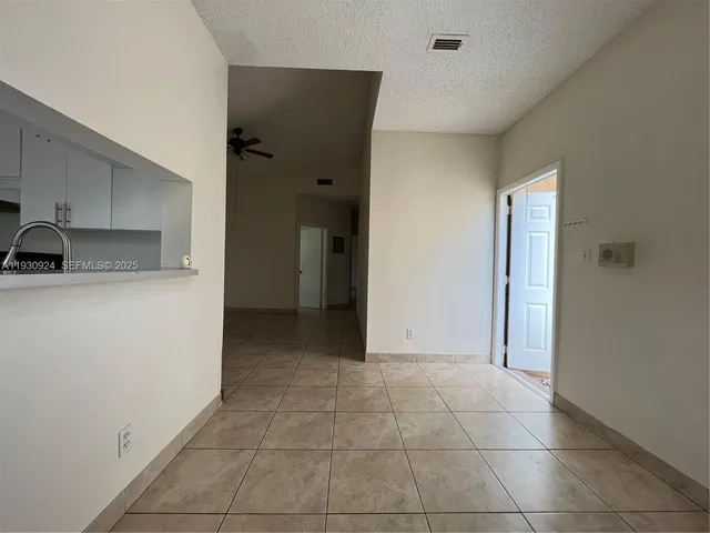 a view of a kitchen with a sink and a refrigerator