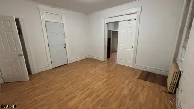 an empty room with wooden floor and a fireplace