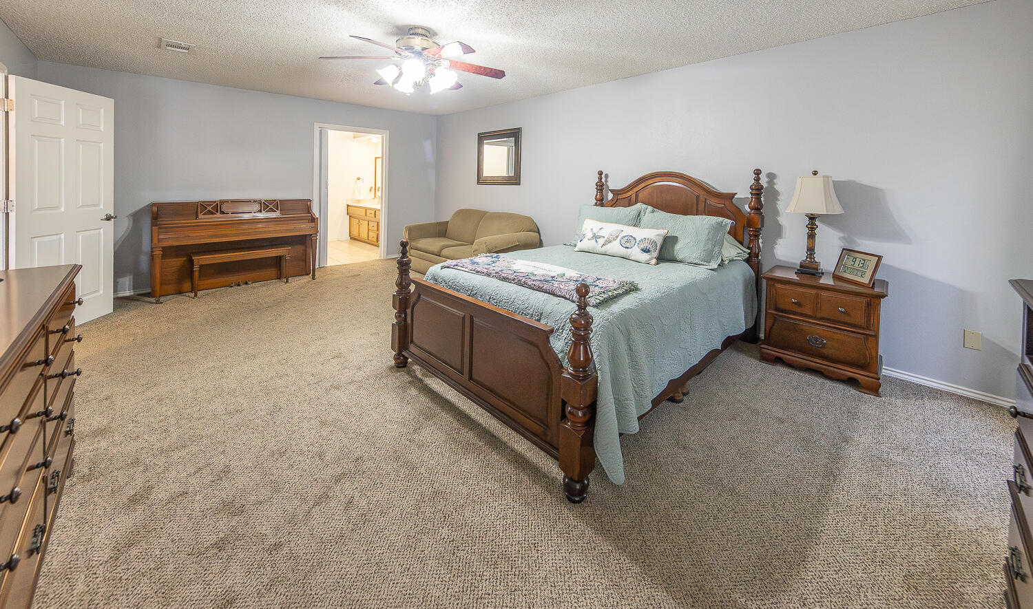5810 80th Street Lubbock, TX 79424 - Photo 12 of 29 a bedroom with a bed and a chandelier
