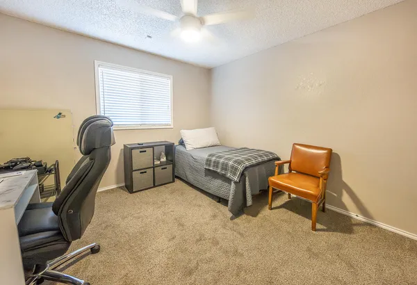a bedroom with a bed chair and window