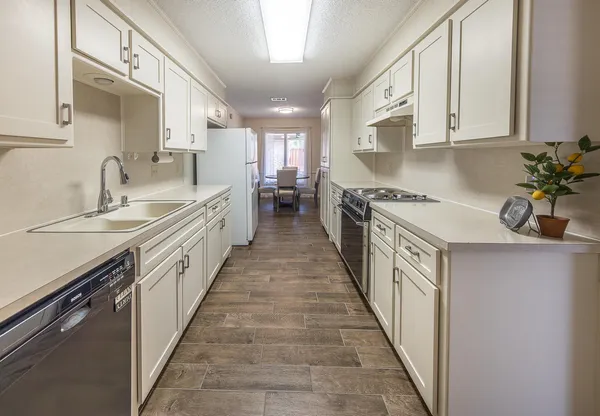a kitchen with stainless steel appliances a sink stove top oven