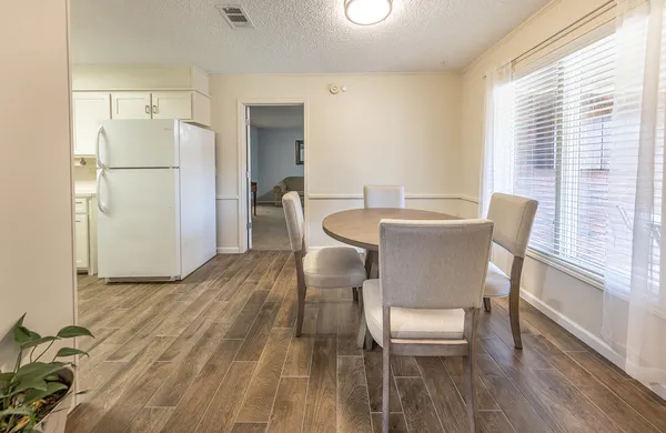 a dining room with furniture and a wooden floor