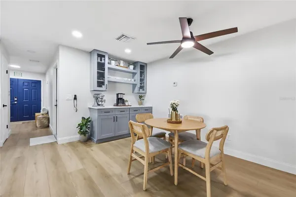 a living room with stainless steel appliances furniture a refrigerator and a sink