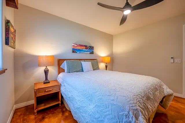 a bedroom with a bed and a lamp on the dresser