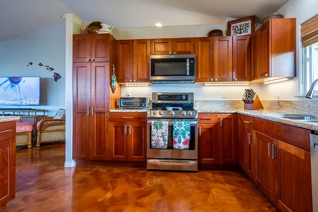 a kitchen with granite countertop a refrigerator and a sink
