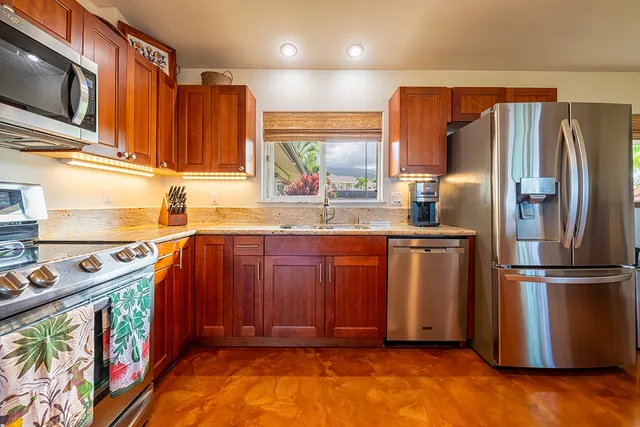 a kitchen with stainless steel appliances granite countertop a refrigerator and a sink