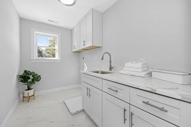 a bathroom with a sink a potted plant and a window