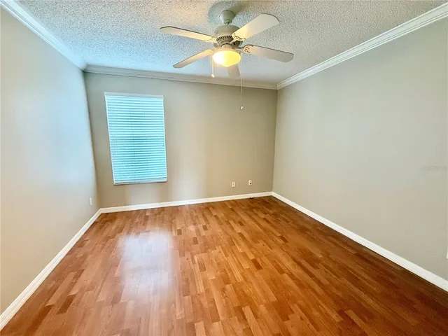 an empty room with a window and a ceiling fan