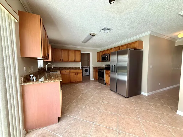 a kitchen with refrigerator and cabinets