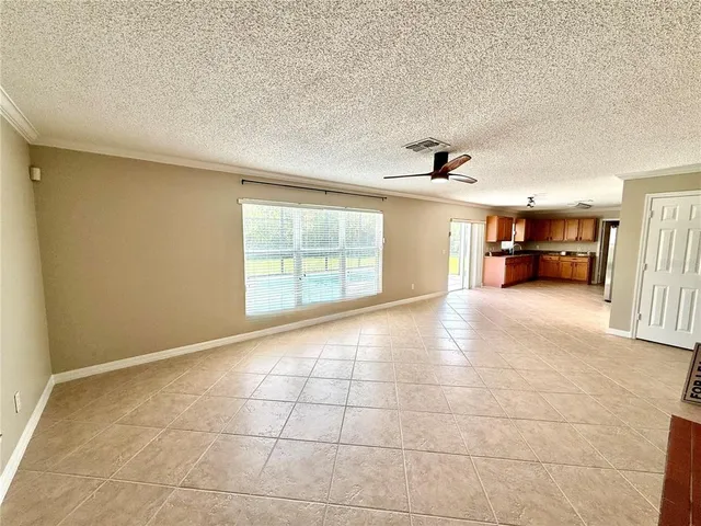 a view of empty room with wooden floor and a window