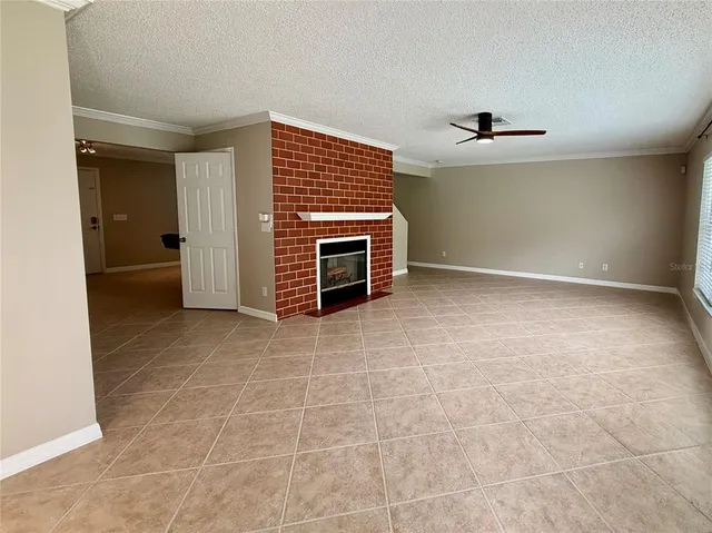 a view of an empty room with a fireplace and a window