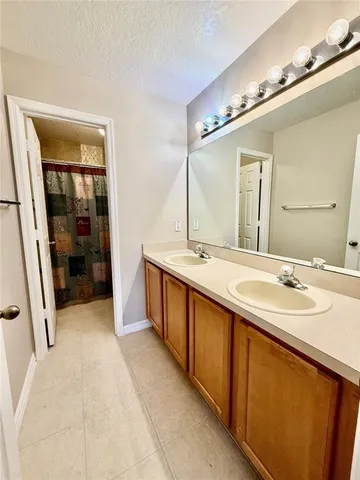 a spacious bathroom with a double vanity sink and a mirror