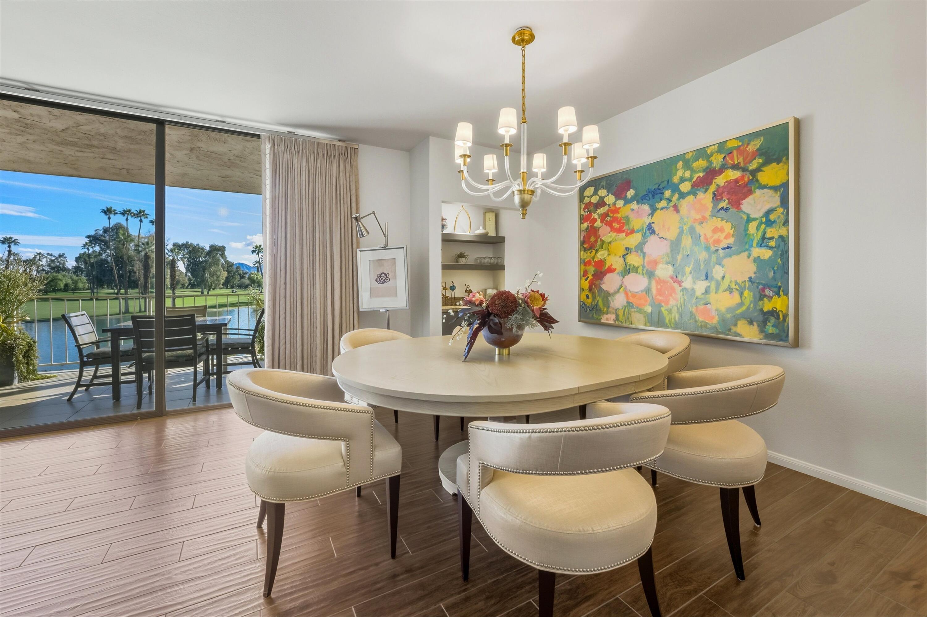 910 Island Drive, Unit 207 Rancho Mirage, CA 92270 - Photo 12 of 27 a view of a dining room with furniture a chandelier and wooden floor
