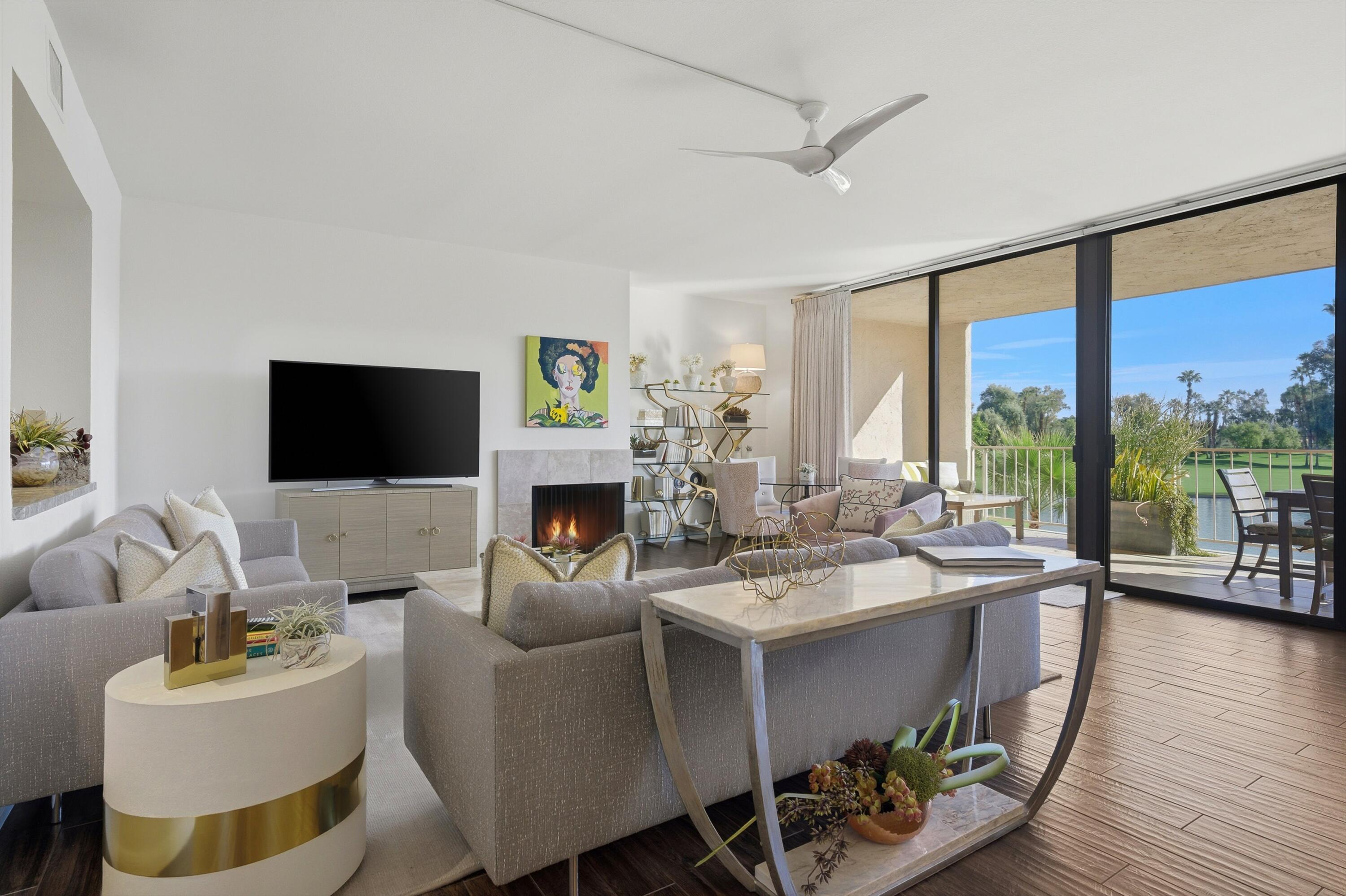 910 Island Drive, Unit 207 Rancho Mirage, CA 92270 - Photo 4 of 27 a living room with furniture a flat screen tv and a floor to ceiling window
