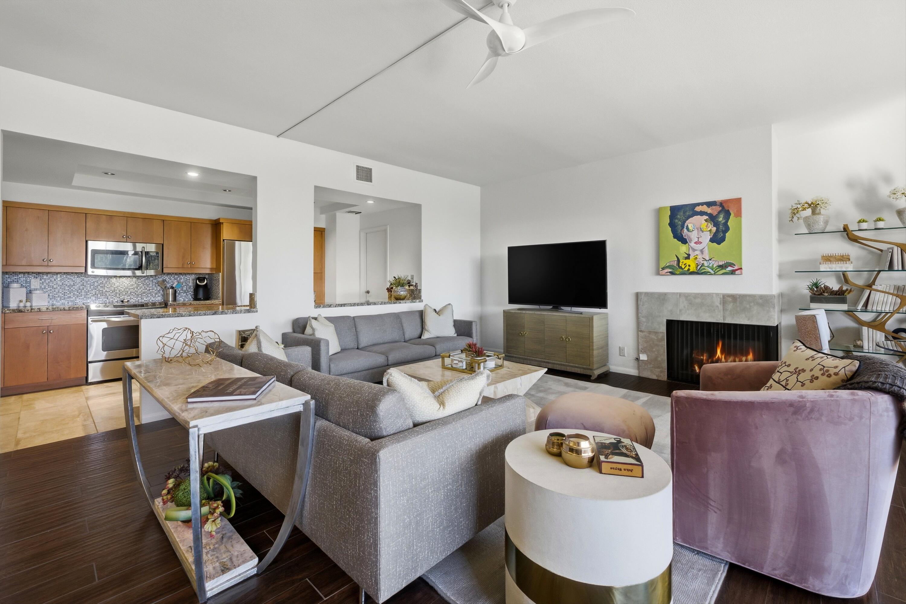 910 Island Drive, Unit 207 Rancho Mirage, CA 92270 - Photo 5 of 27 a living room with furniture a flat screen tv and a fireplace