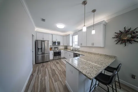 a kitchen with refrigerator and chairs