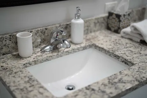 a bathroom with a granite countertop sink toilet and shower
