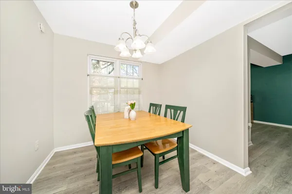 a dining room with stainless steel appliances a table chairs and chandelier