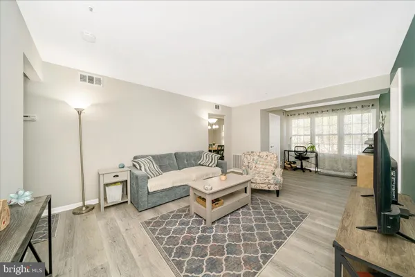 a living room with furniture a flat screen tv and a window