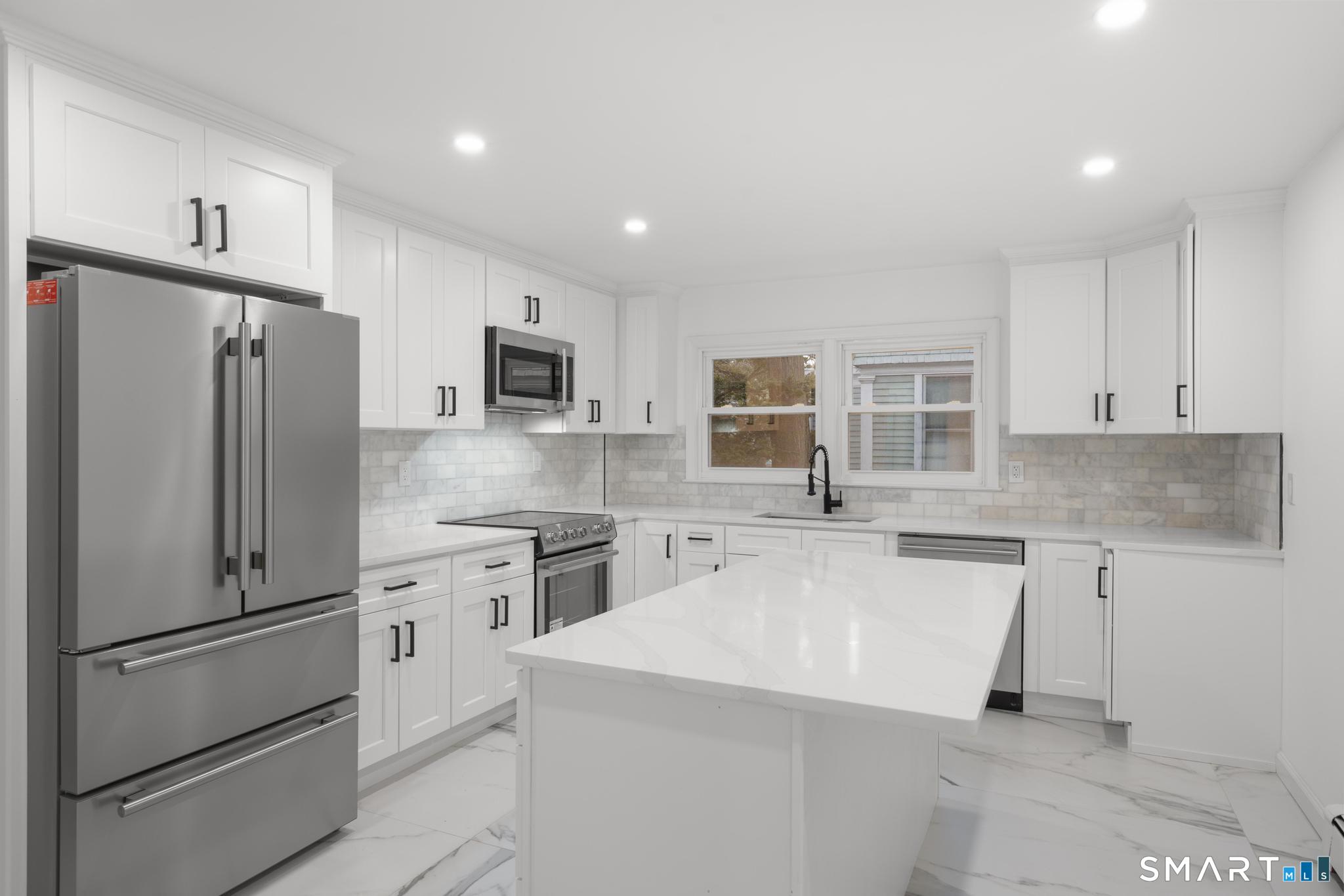 74 Cold Spring Street New Haven, CT 06511 - Photo 13 of 40 a kitchen with white cabinets and stainless steel appliances