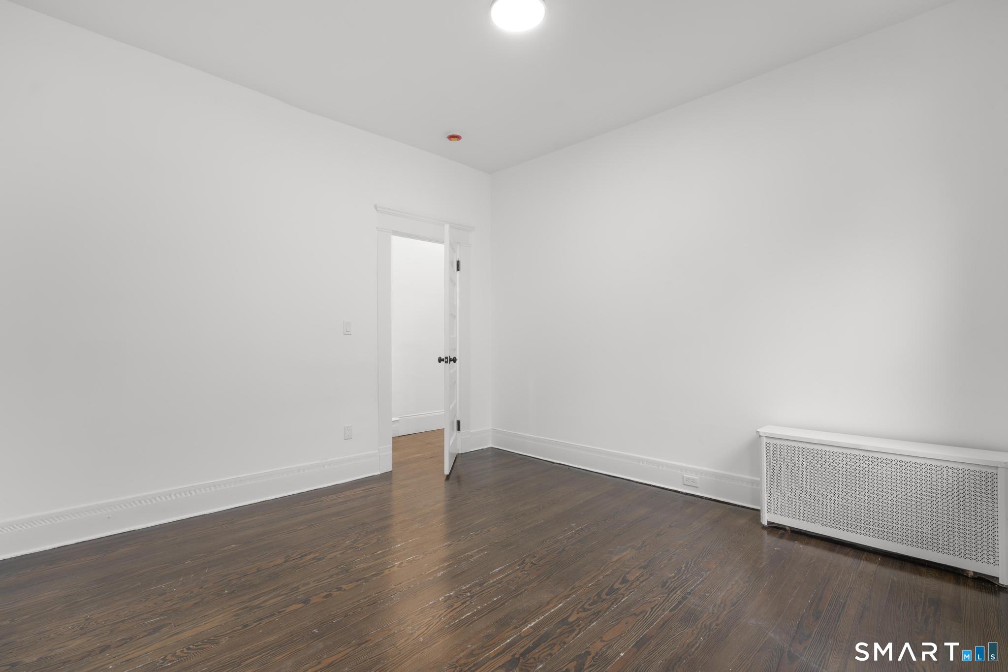 74 Cold Spring Street New Haven, CT 06511 - Photo 21 of 40 a view of an empty room with wooden floor and a window