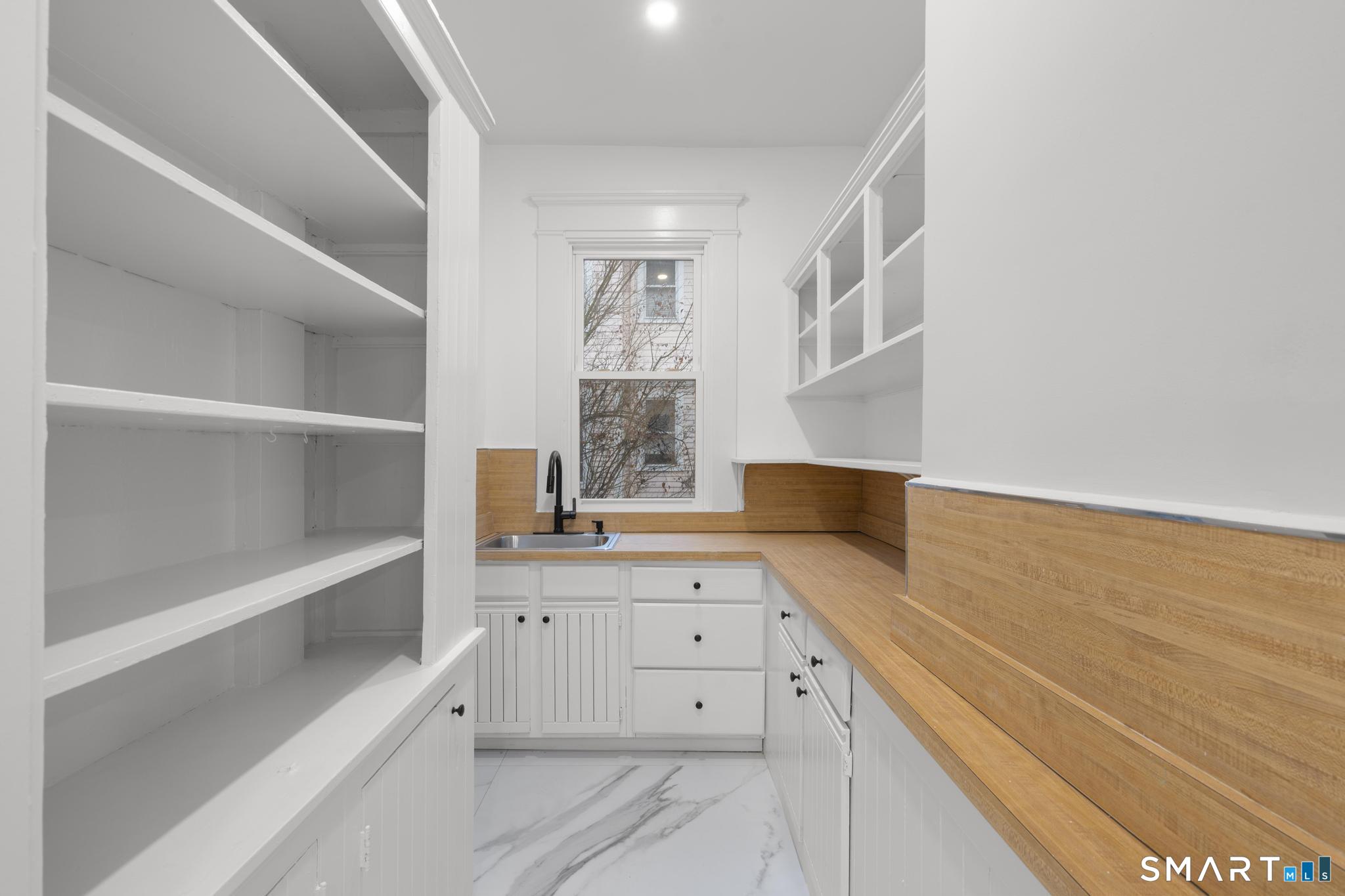74 Cold Spring Street New Haven, CT 06511 - Photo 9 of 40 a view of a kitchen with a sink and dishwasher with white cabinets