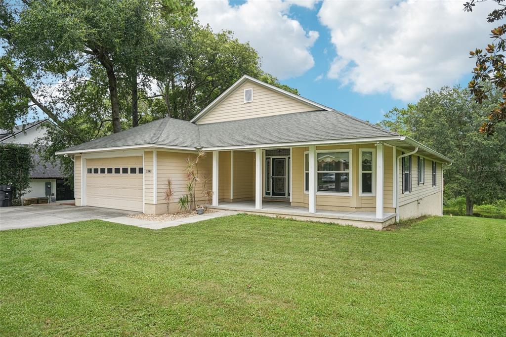 a view of a house with a yard and sitting area