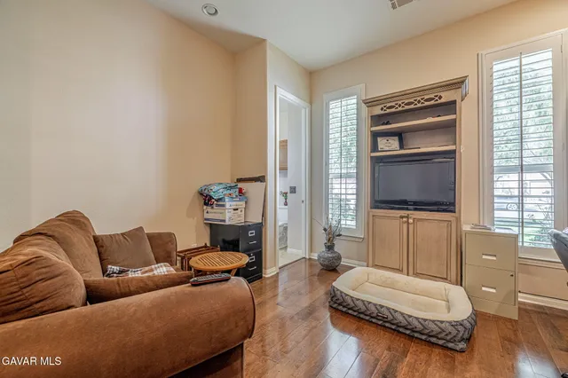 a spacious bedroom with a bed a dresser and potted plants