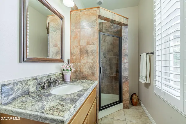 a bathroom with a granite countertop sink double and mirror