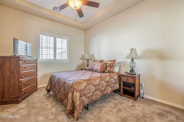a spacious bedroom with a bed and a chandelier