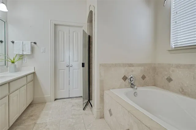 a bathroom with a tub sink and mirror