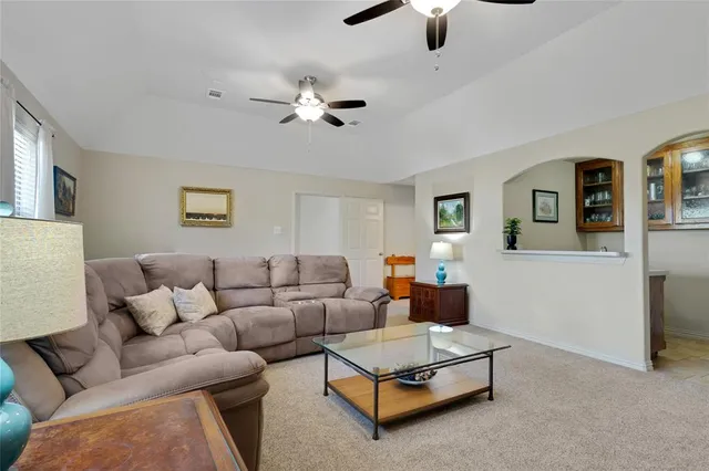 a living room with furniture and a ceiling fan