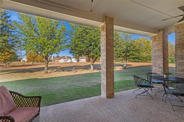 a view of a porch with furniture and garden