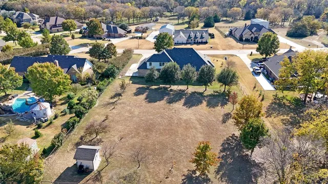 an aerial view of a house with a yard and lake view