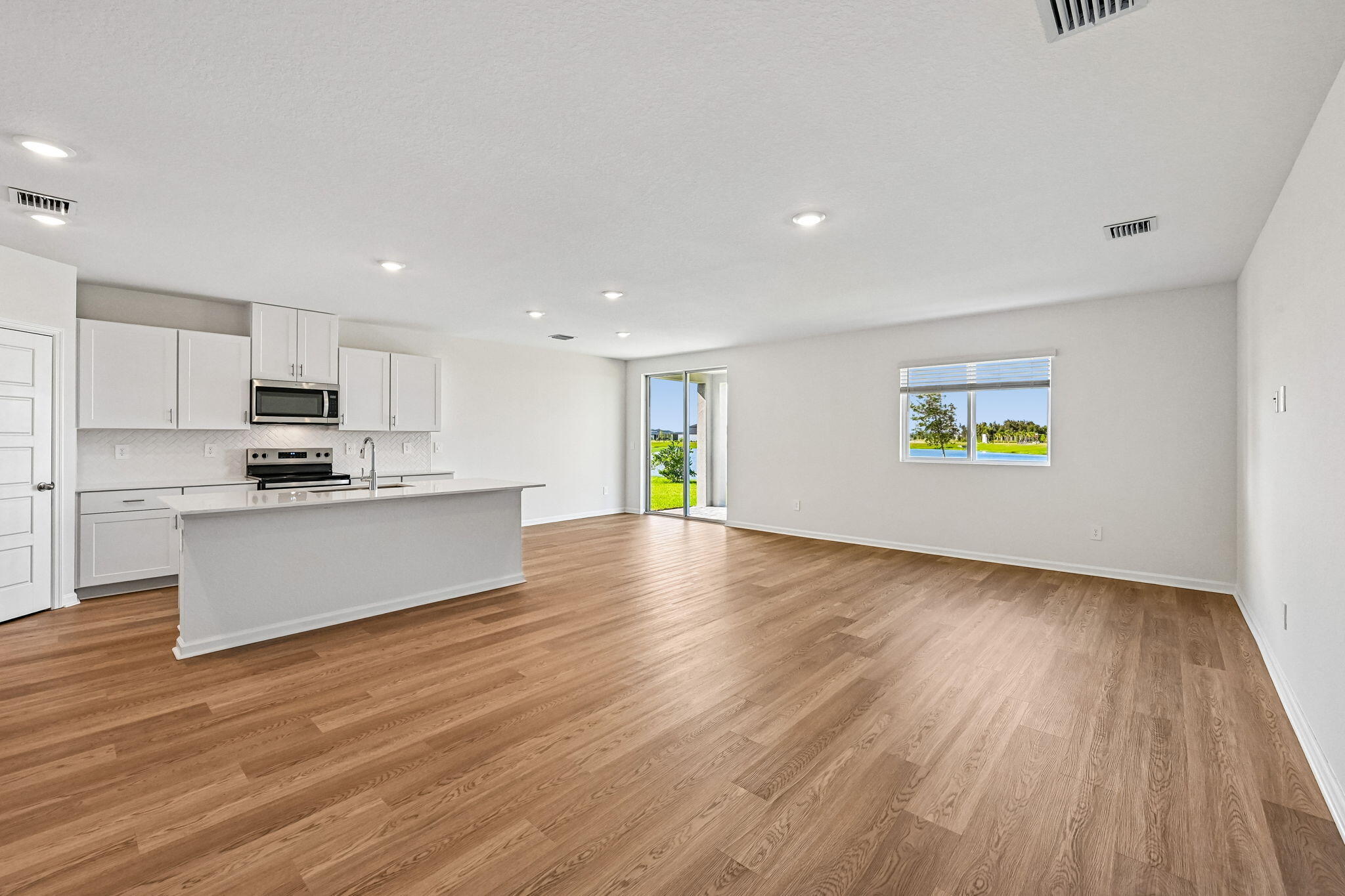 14503 Southwest New Dawn Road Indiantown, FL 34956 - Photo 5 of 42 a view of a kitchen with wooden floor and a window