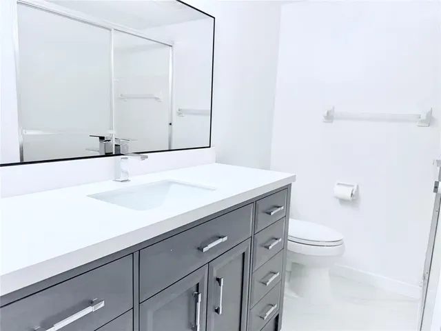 a bathroom with a sink a toilet and vanity