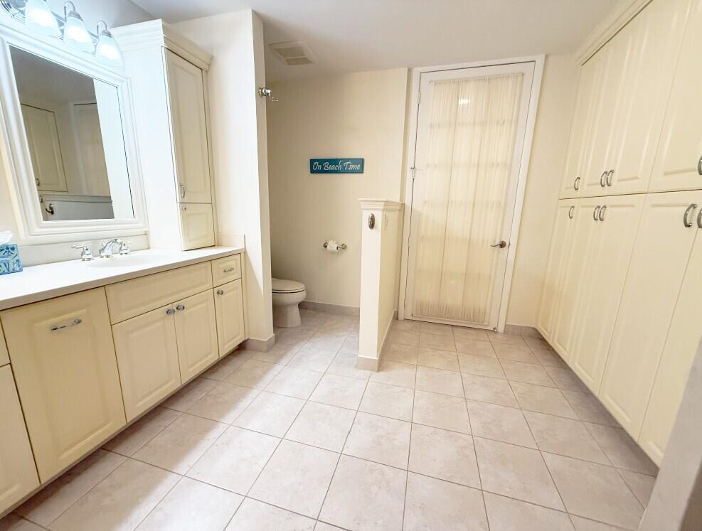 114 Beach Summit Court Jupiter, FL 33477 - Photo 22 of 32 a spacious bathroom with a granite countertop sink a mirror and a