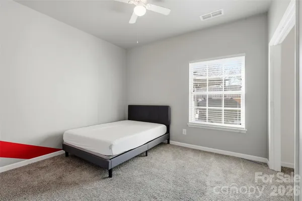 en empty room with windows and chandelier fan