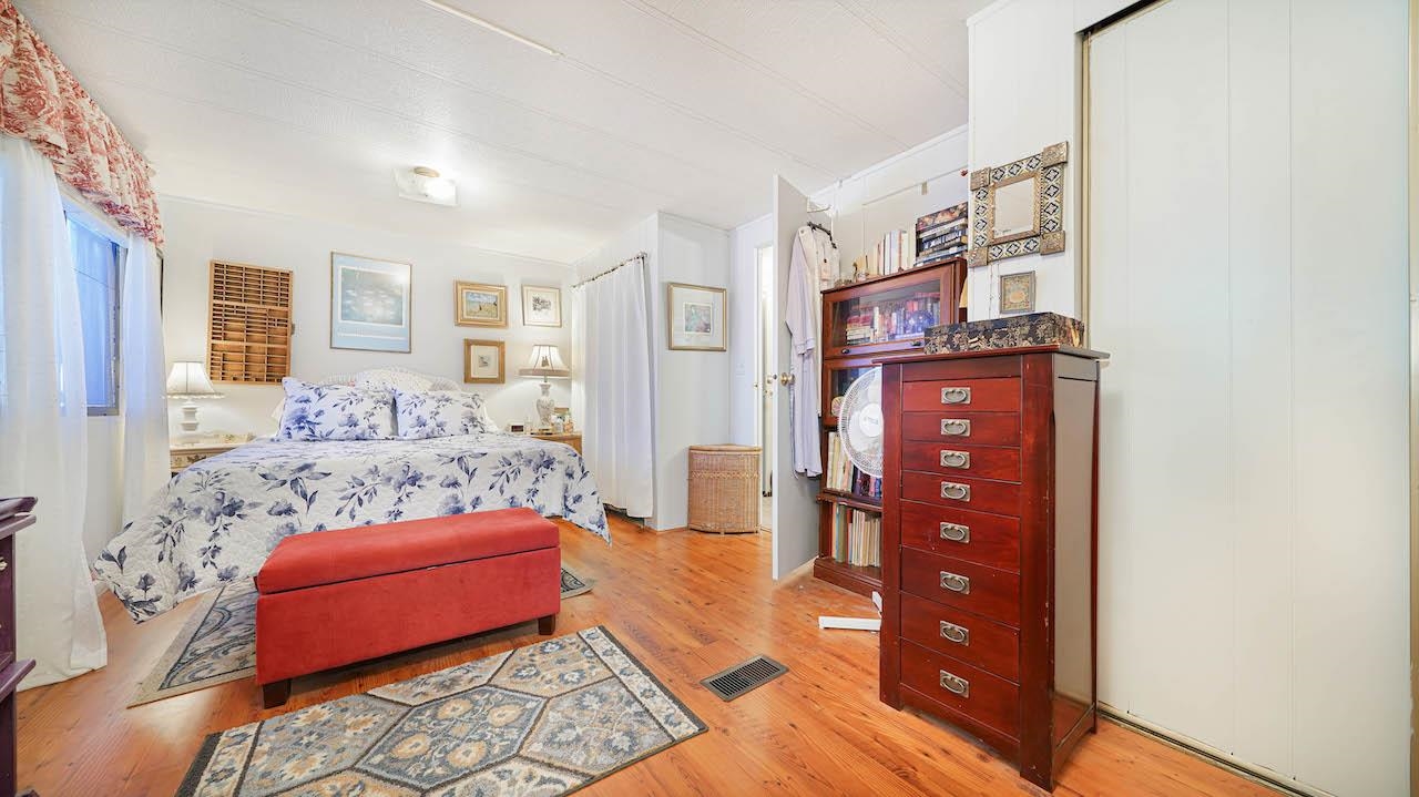 3251 E Road, Unit 100 Clifton, CO 81520 - Photo 13 of 22 a bedroom with furniture and wooden floor