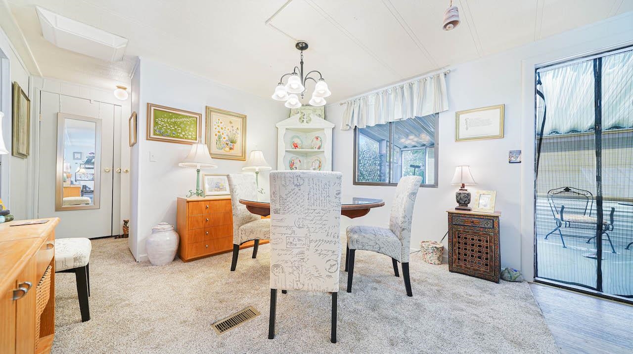 3251 E Road, Unit 100 Clifton, CO 81520 - Photo 5 of 22 a living room with furniture a dining table and a chandelier