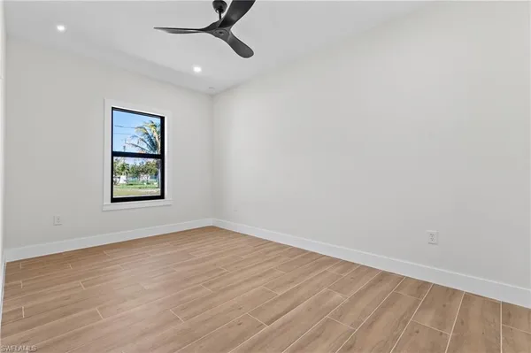 an empty room with a window and a ceiling fan