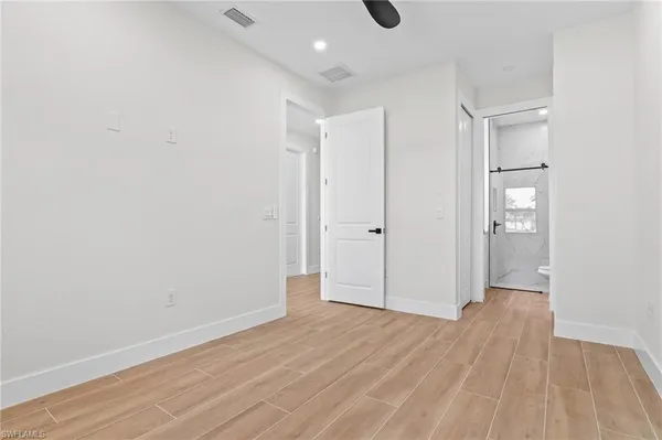 a view of empty room with wooden floor