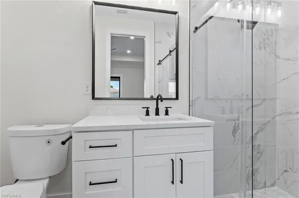 a bathroom with a sink toilet vanity and shower