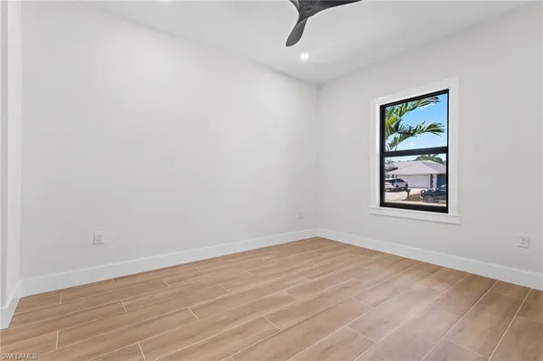 an empty room with a window and ceiling fan