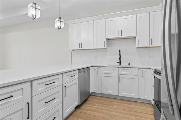 a kitchen with white cabinets and sink