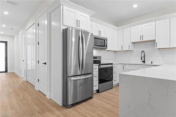 a kitchen with stainless steel appliances a refrigerator sink and cabinets